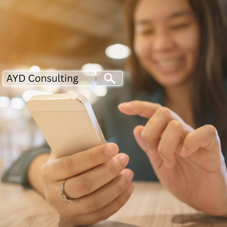 Person using a smartphone to search for AYD small business consulting services online.